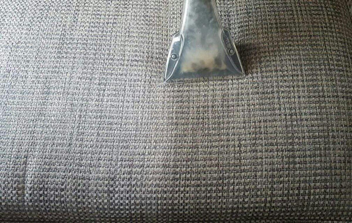 Steam cleaning wand extracting dirt from woven fabric upholstery